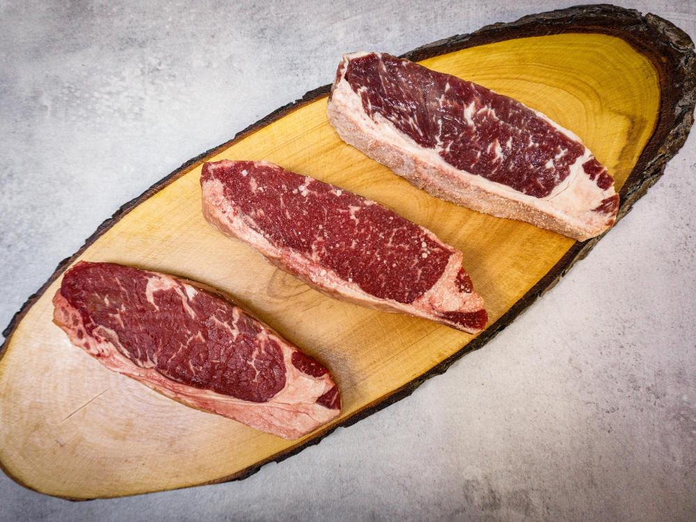 Gesalzenes rohes Steak auf Baumscheibe
