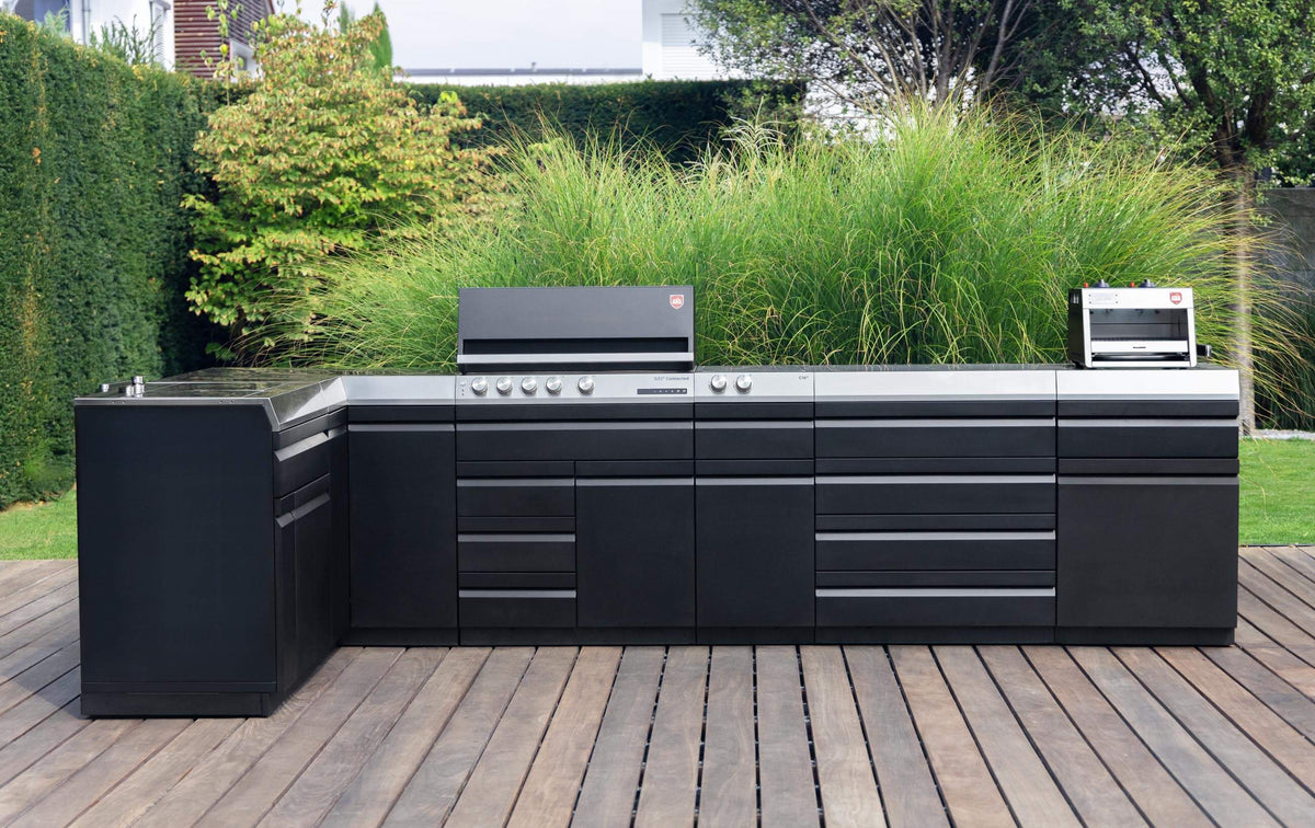 Eine Outdoor-Küche auf einer Terrasse in einem begrünten Garten