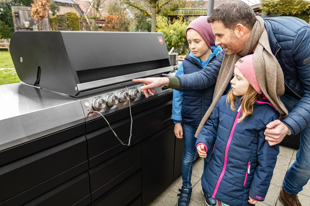 Familie schaut sich den Otto Wilde Gasgrill G32 an